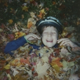 Boy laughing in leaves